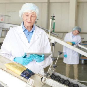 people checking the quality of packaged food in a factory
