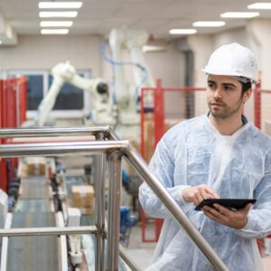 a person in safety gear looking at a checklist in a packing room